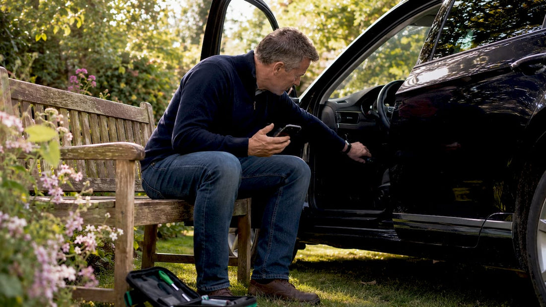Driver plugging GPS tracker into car OBD2 port
