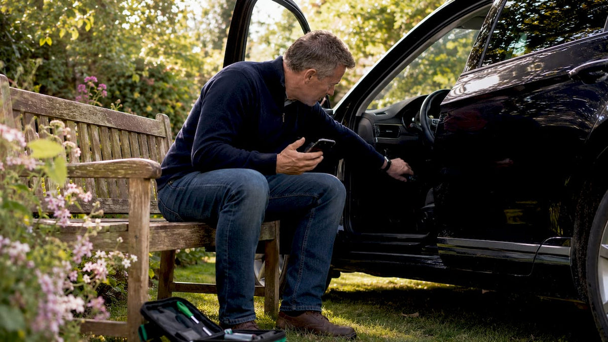 Driver plugging GPS tracker into car OBD2 port