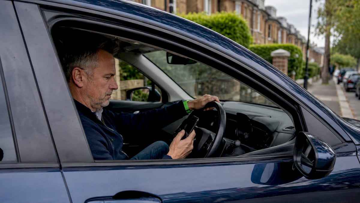 Driver setting up car geofence on smartphone inside car