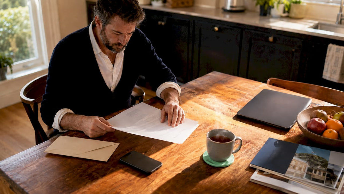 Man reviewing lease agreement documents at home