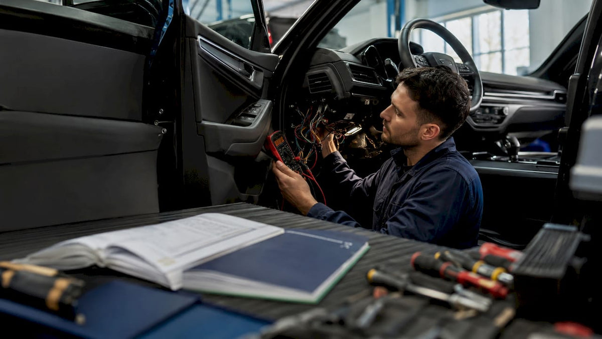 Technician installing hardwired car tracker wiring