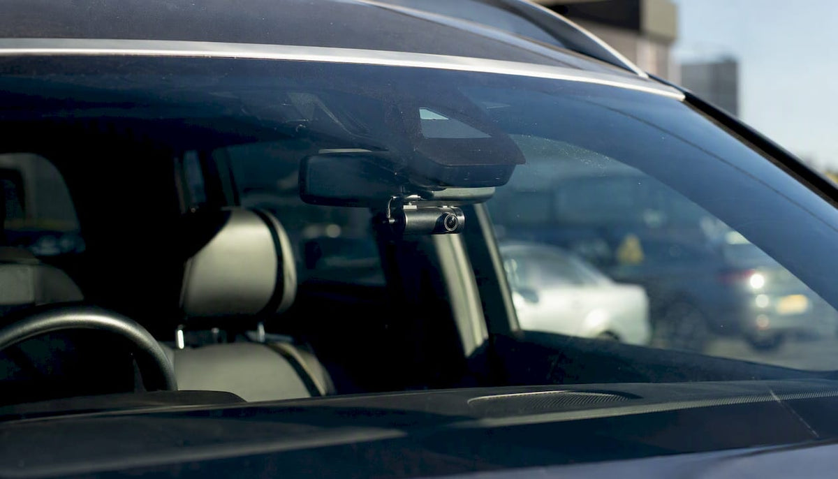 Dashcam mounted behind rear-view mirror
